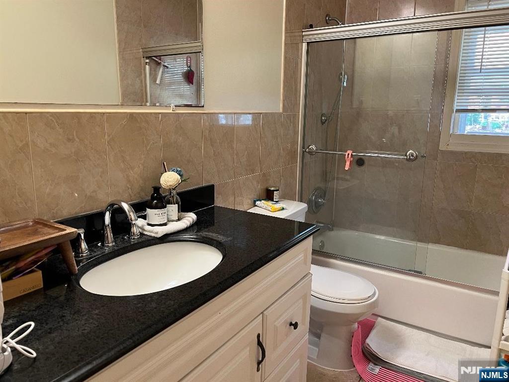24 Ruth Lane Demarest, NJ 07627 - Photo 6 of 14 a bathroom with a granite countertop sink toilet a mirror and shower