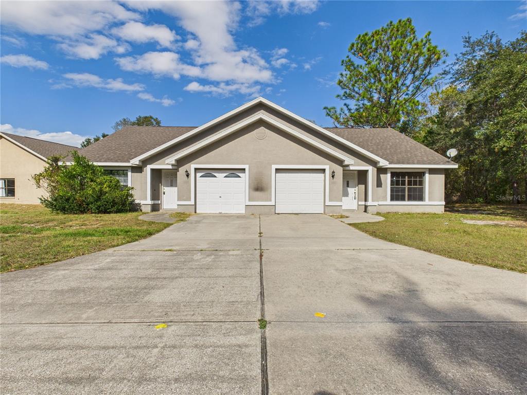 4116 Jason Road Spring Hill, FL 34608 - Photo 1 of 66 a front view of a house with a garden and plants