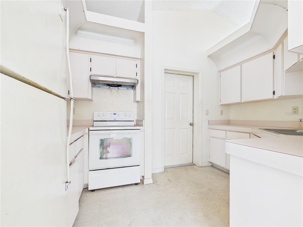 4116 Jason Road Spring Hill, FL 34608 - Photo 12 of 66 a kitchen with white cabinets and white appliances