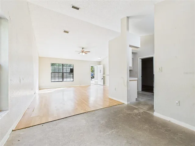 a view of an empty room with wooden floor