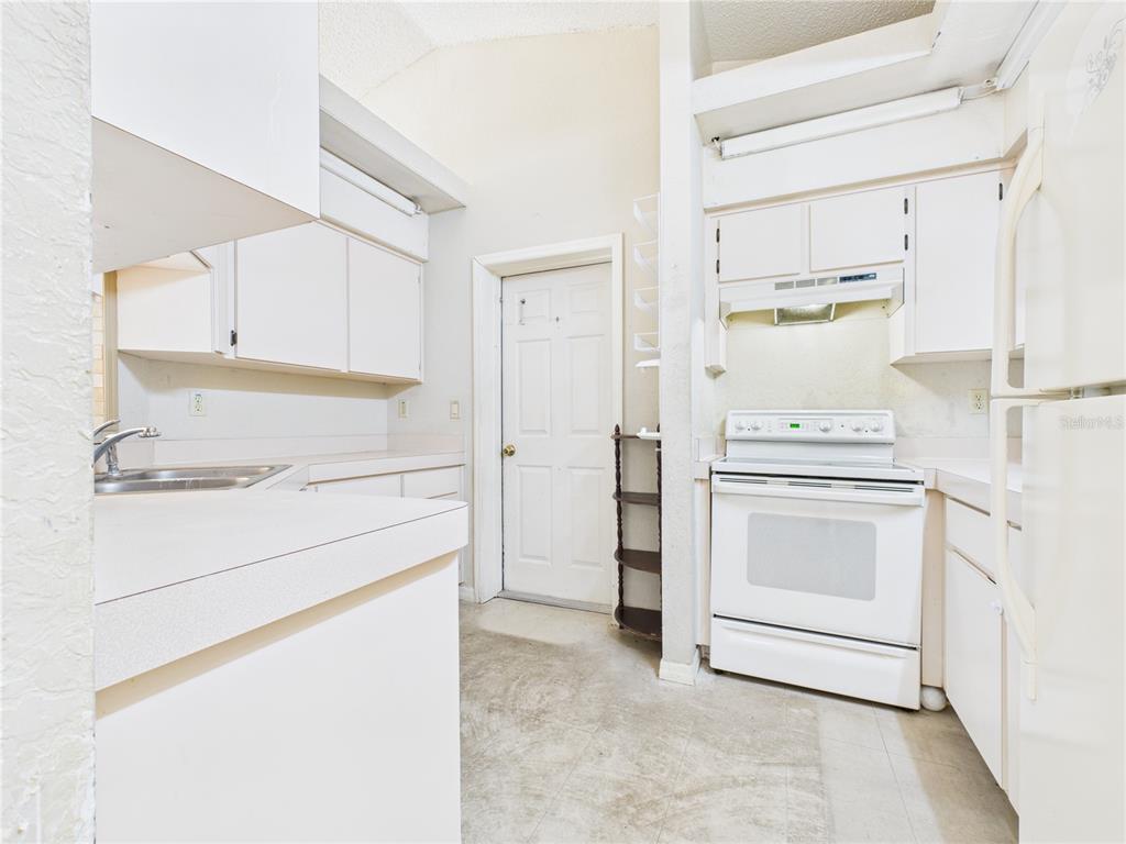 4116 Jason Road Spring Hill, FL 34608 - Photo 24 of 66 a kitchen with white cabinets and white appliances