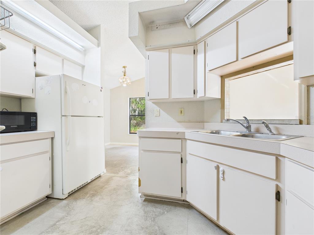 4116 Jason Road Spring Hill, FL 34608 - Photo 25 of 66 a kitchen with cabinets appliances and a counter space