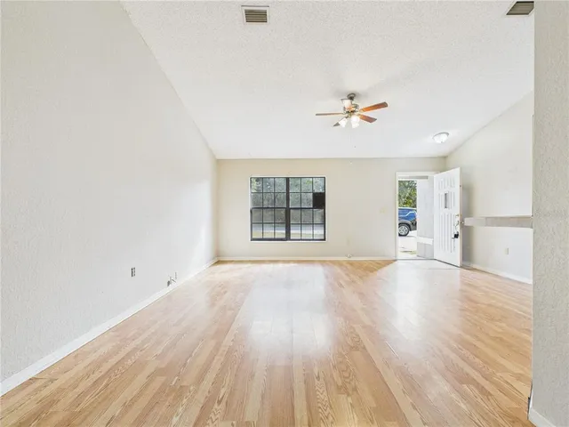 a view of a hallway with wooden floor and a chandelier