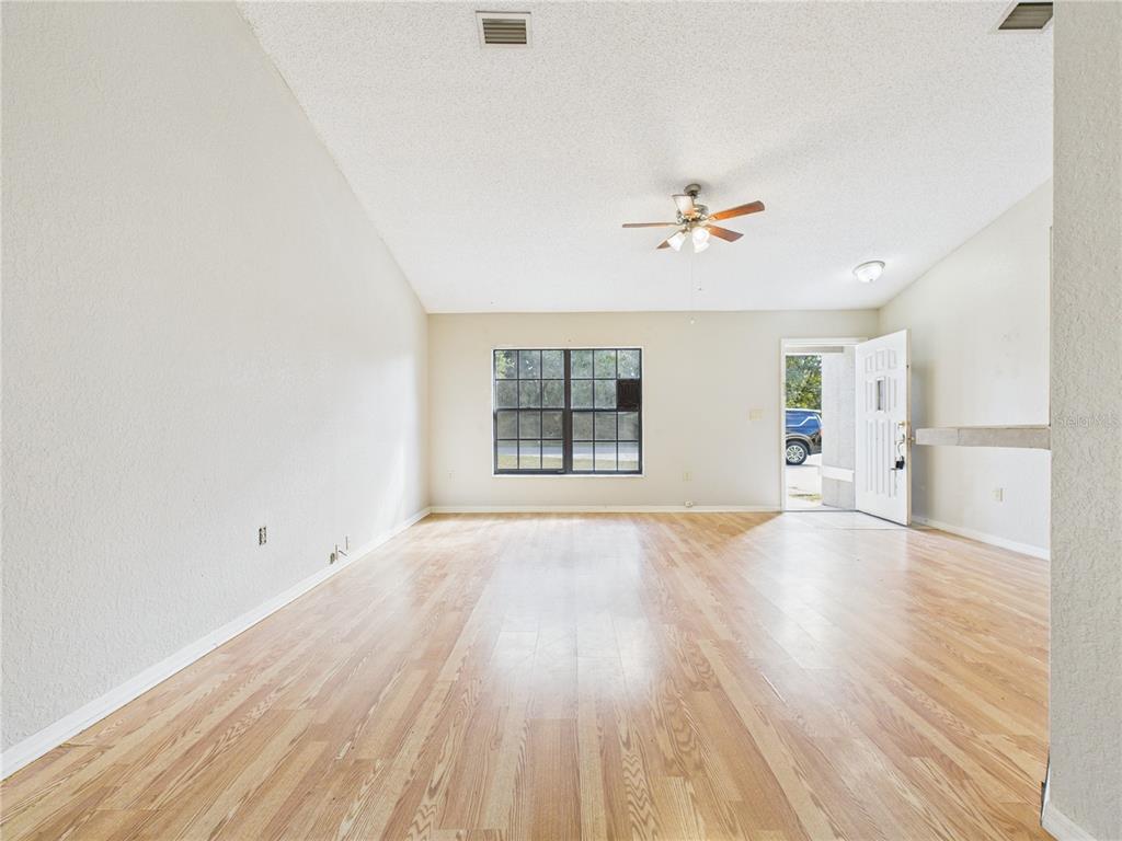 4116 Jason Road Spring Hill, FL 34608 - Photo 27 of 66 an empty room with wooden floor ceiling fan and windows