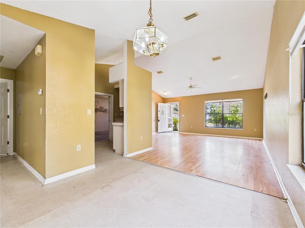 4116 Jason Road Spring Hill, FL 34608 - Photo 34 of 66 a view of a hallway with wooden floor and a chandelier