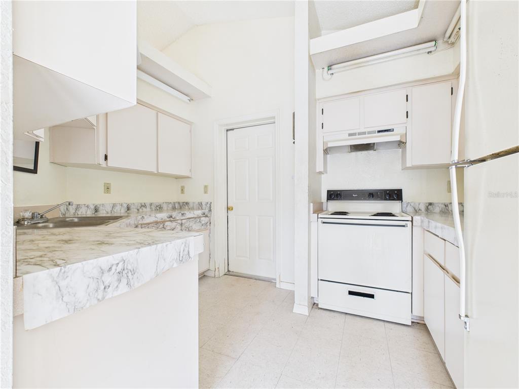 4116 Jason Road Spring Hill, FL 34608 - Photo 47 of 66 a kitchen with white cabinets and white appliances