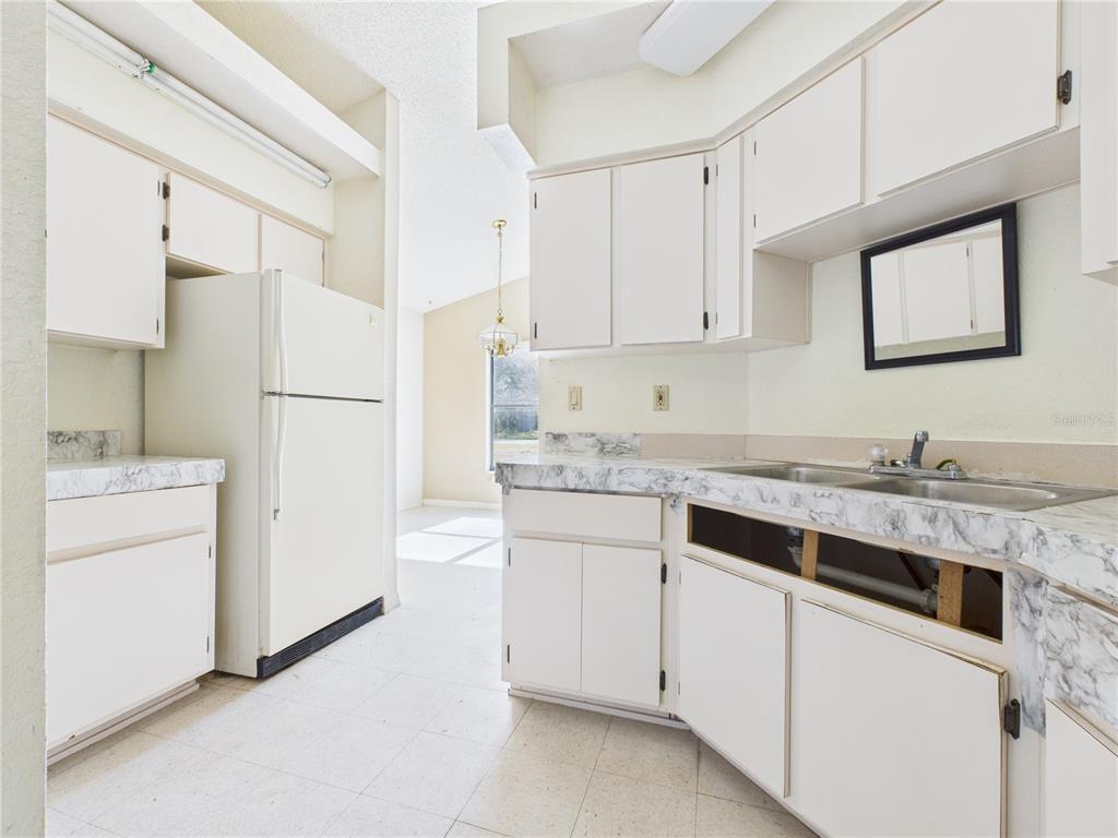 4116 Jason Road Spring Hill, FL 34608 - Photo 48 of 66 a kitchen with granite countertop white cabinets and white appliances