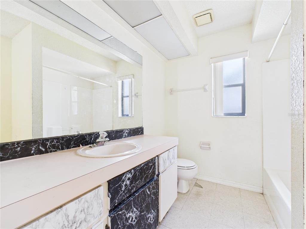 4116 Jason Road Spring Hill, FL 34608 - Photo 52 of 66 a bathroom with a sink a toilet a mirror and vanity