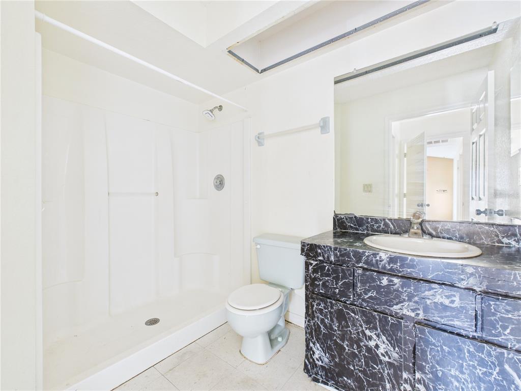 4116 Jason Road Spring Hill, FL 34608 - Photo 54 of 66 a bathroom with a granite countertop sink a toilet a mirror and shower