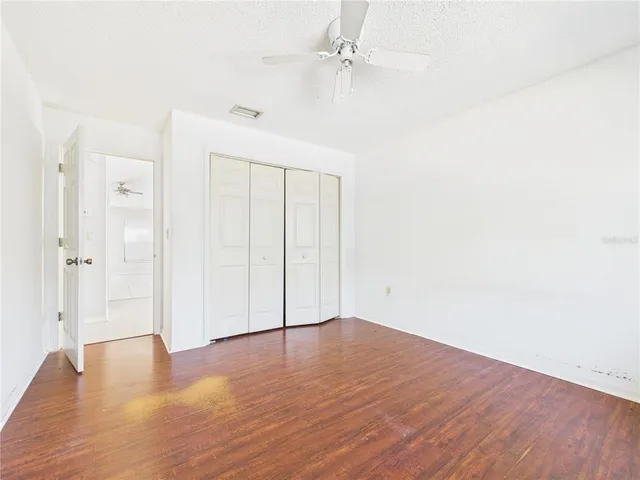 a view of an empty room with wooden floor