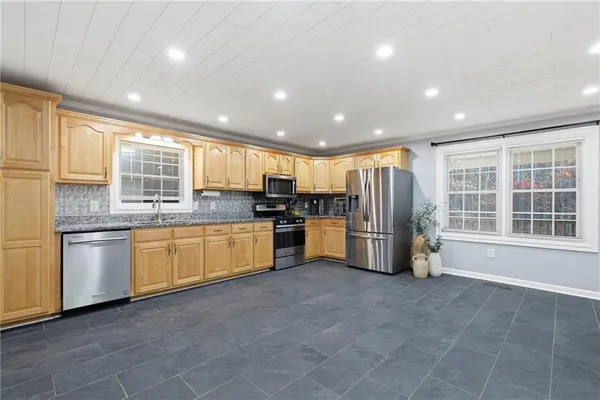 a kitchen with granite countertop a refrigerator and white cabinets