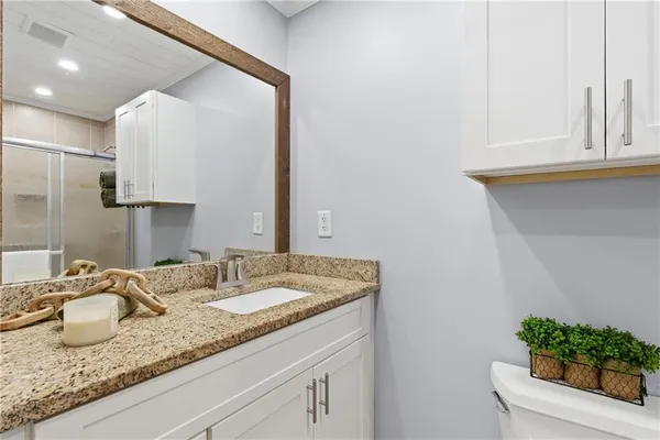a bathroom with a granite countertop sink and a mirror