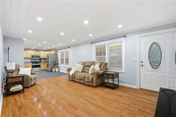 a living room with furniture a table and wooden floor