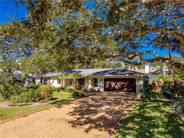 a front view of a building with a garden and plants