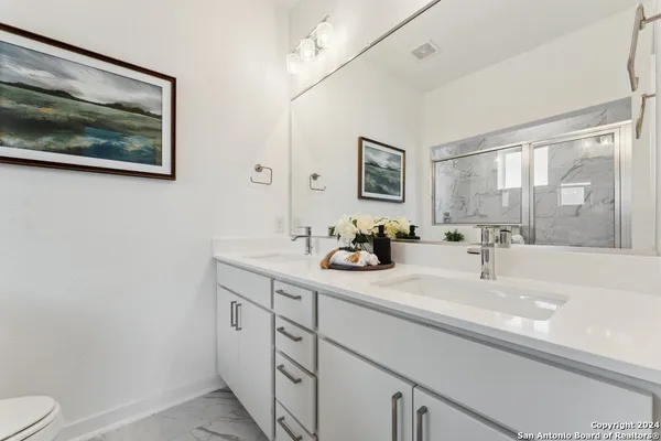 a bathroom with a sink mirror and toilet