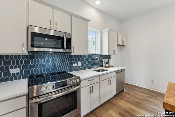 a kitchen with a stove microwave and sink