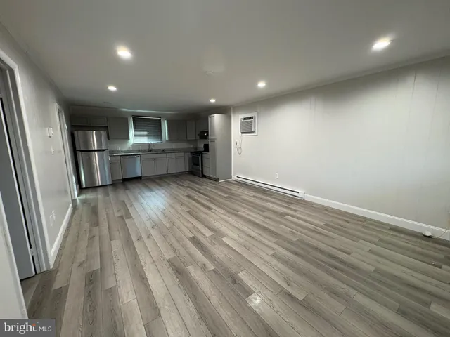 an empty room with wooden floor and window