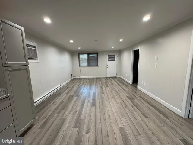 an empty room with wooden floor and entrance