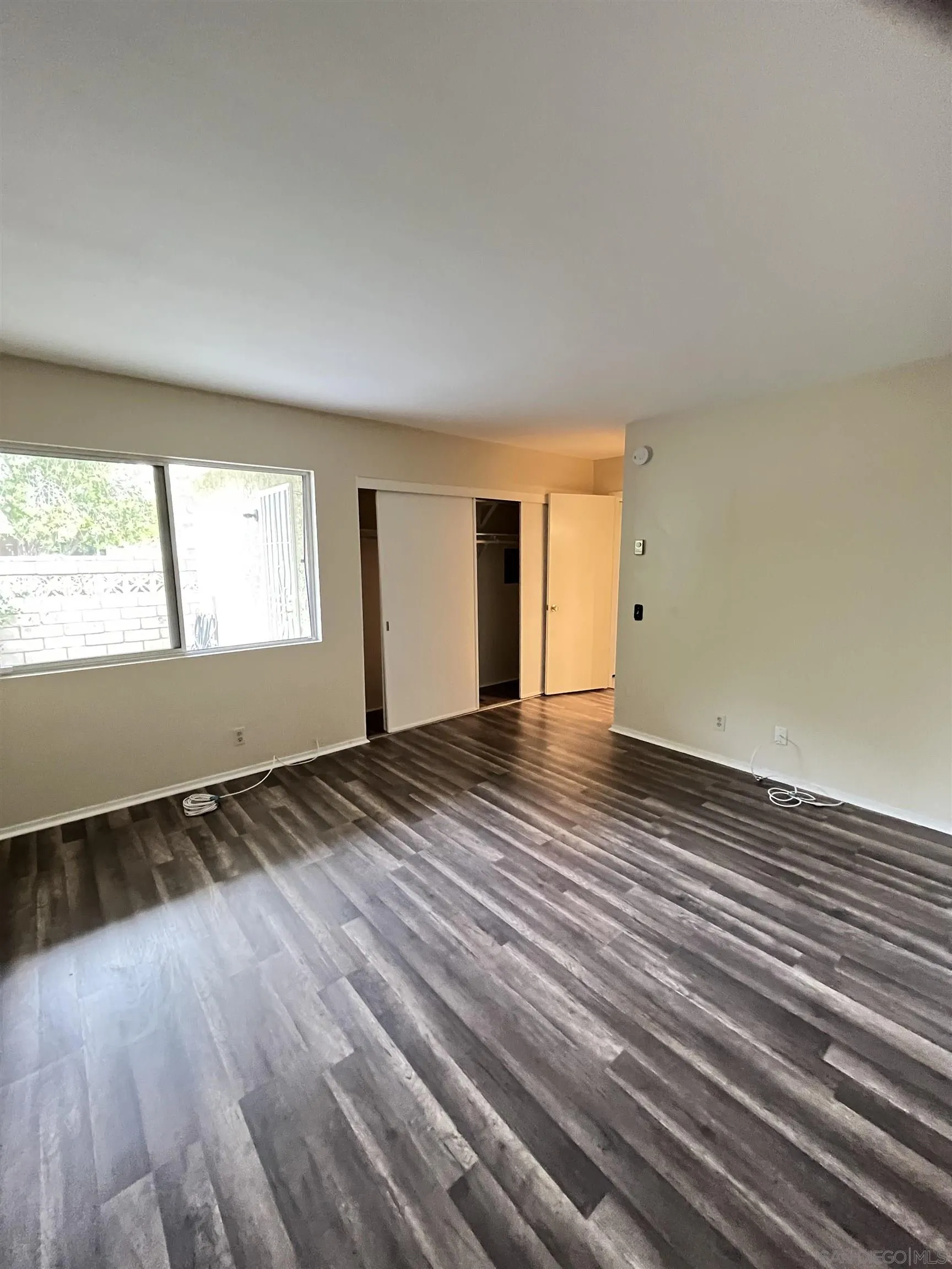3719 Bay Leaf Way Oceanside, CA 92057 - Photo 12 of 33 a view of an empty room with wooden floor and a window