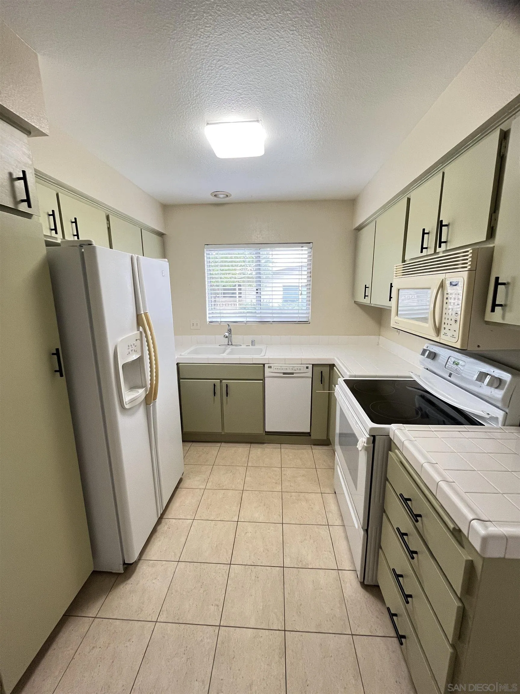 3719 Bay Leaf Way Oceanside, CA 92057 - Photo 15 of 33 a kitchen with a stove a refrigerator and a sink