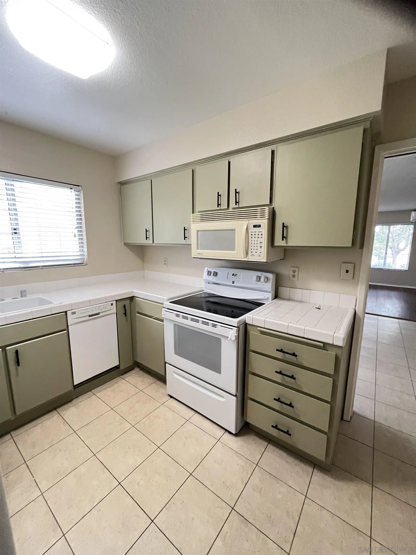 3719 Bay Leaf Way Oceanside, CA 92057 - Photo 17 of 33 a kitchen with a stove sink and cabinets