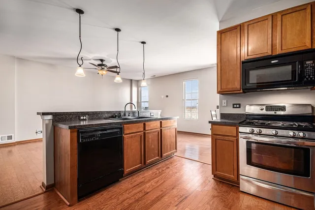 a kitchen with stainless steel appliances granite countertop a stove a sink and a microwave