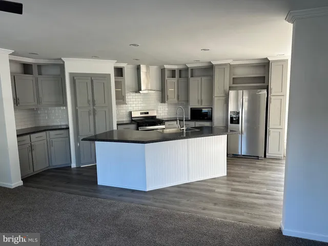 a kitchen with a refrigerator sink and cabinets