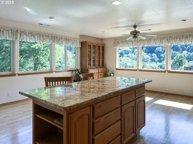 a kitchen with granite countertop a stove a sink and wooden floor