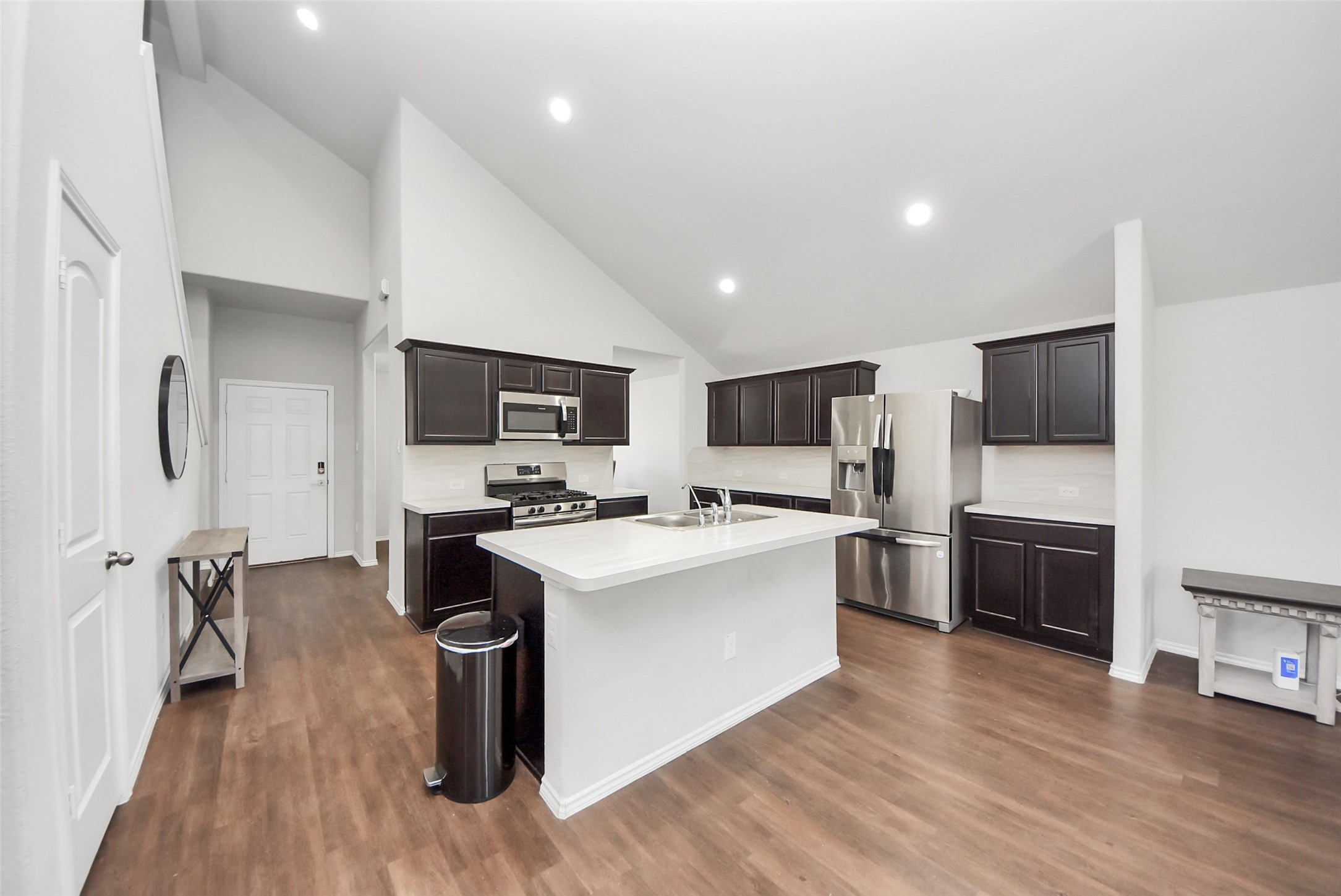 1227 Baja Vista Way Channelview, TX 77530 - Photo 7 of 25 a kitchen with stainless steel appliances a stove top oven a sink dishwasher a refrigerator white cabinets and wooden floor