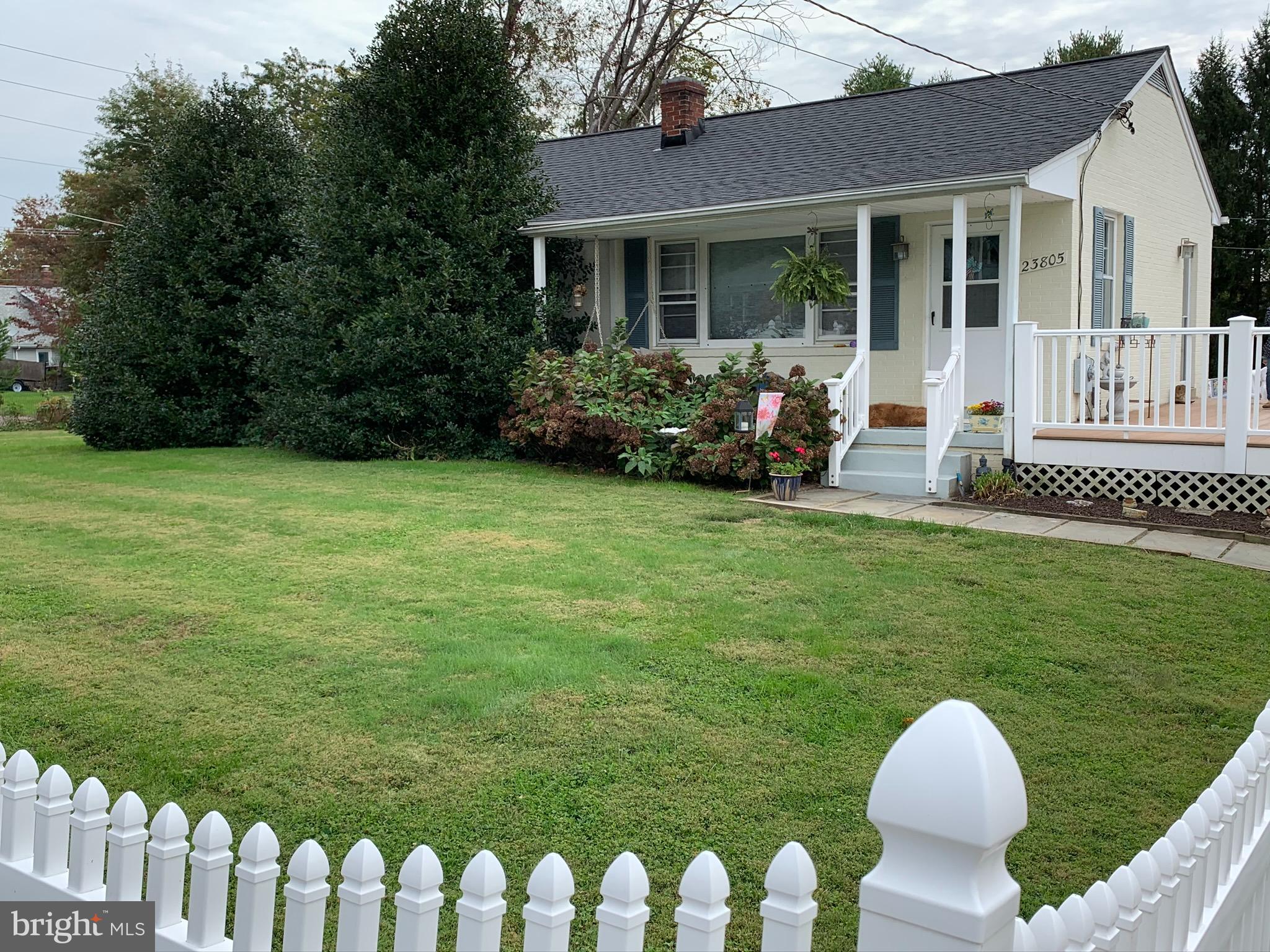 a view of a house with a yard and porch