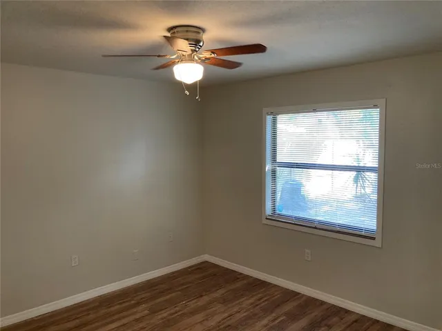 a view of an empty room with wooden floor