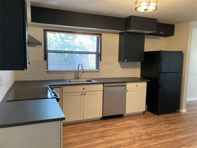 a kitchen with granite countertop a refrigerator and a sink