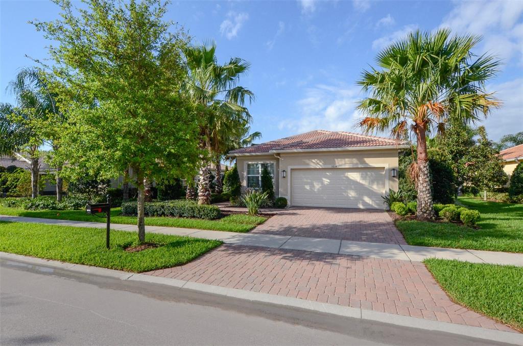 a front view of a house with a yard and trees