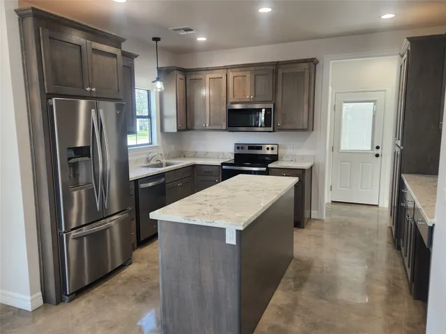 a kitchen with stainless steel appliances granite countertop wooden cabinets a refrigerator and dishwasher