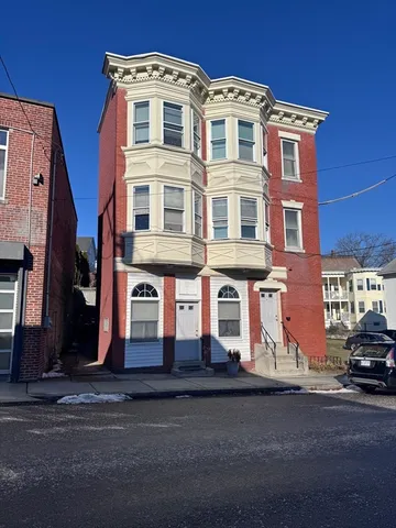 a front view of a residential apartment building with a yard