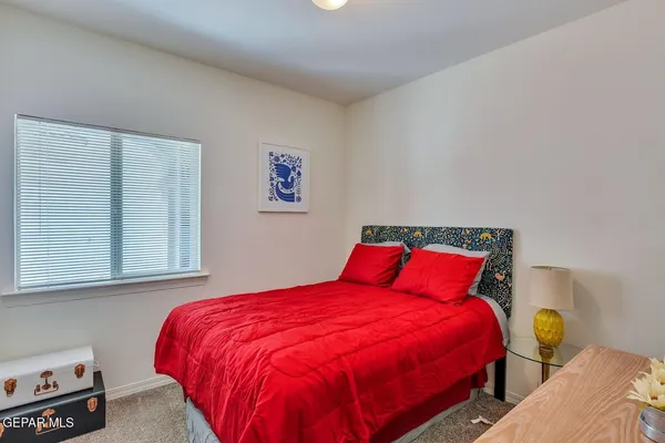 a bedroom with a bed and painting on the wall