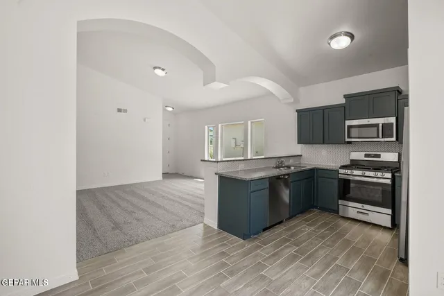 a kitchen with stainless steel appliances granite countertop a stove top oven and sink