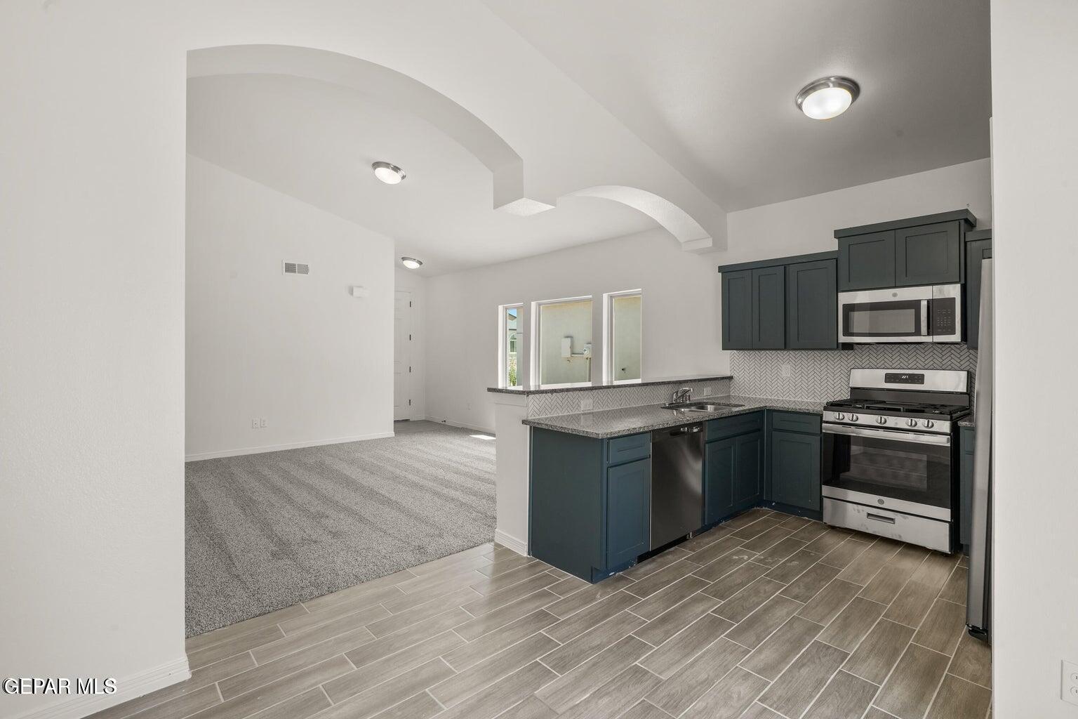 13090 Beccles Street El Paso, TX 79928 - Photo 5 of 23 a kitchen with stainless steel appliances granite countertop a stove top oven and sink