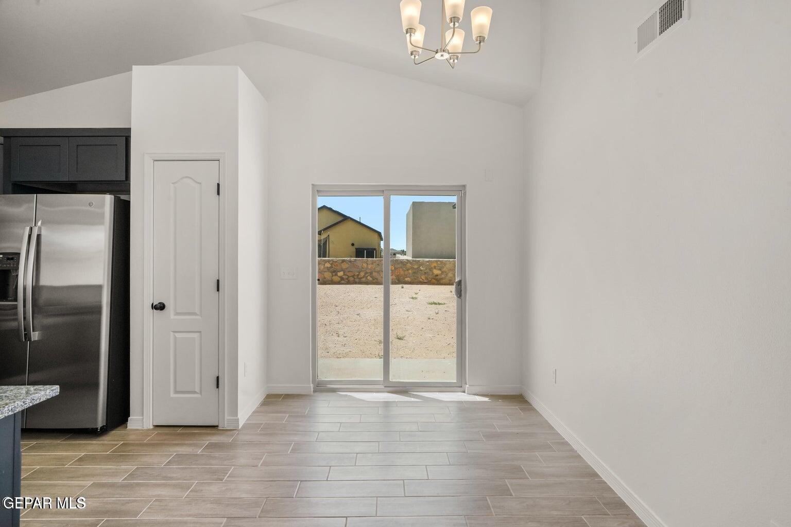13090 Beccles Street El Paso, TX 79928 - Photo 6 of 23 an empty room with wooden floor and mirror