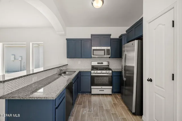 a kitchen with kitchen island granite countertop stainless steel appliances and wooden cabinets