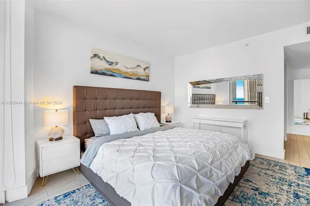 a bedroom with a bed and a painting on the wall