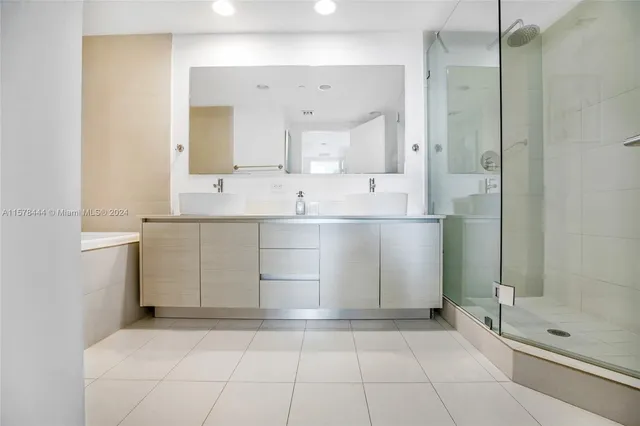 a bathroom with a tub shower and sink