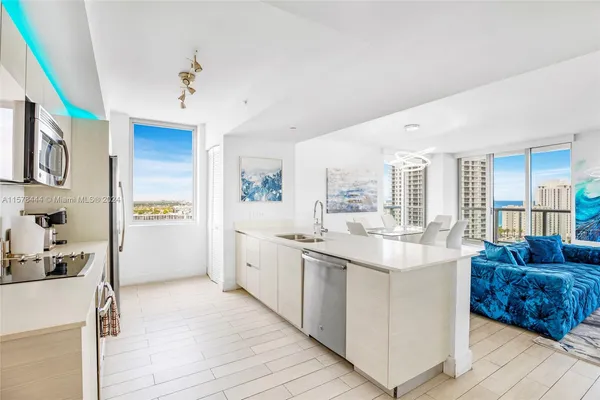 a kitchen with stainless steel appliances granite countertop a sink and a refrigerator