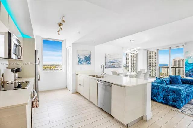a kitchen with stainless steel appliances granite countertop a sink and a refrigerator