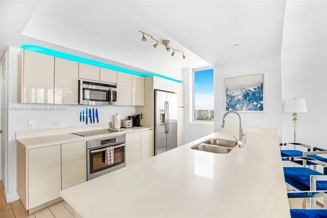 a kitchen with kitchen island a stove a sink and a refrigerator