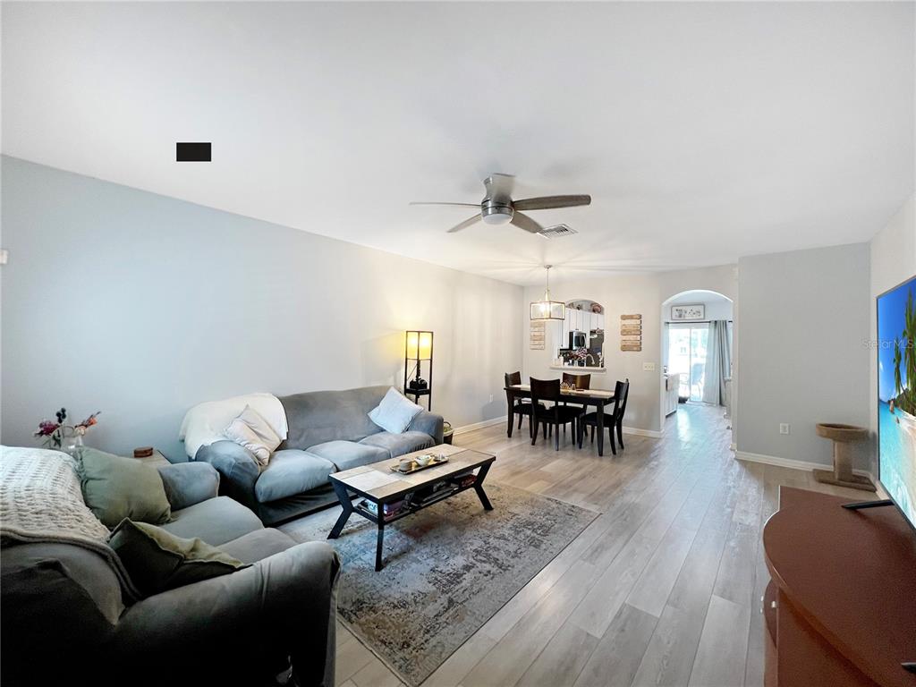 15767 Stable Run Drive Spring Hill, FL 34610 - Photo 6 of 34 a living room with furniture and a dining table with kitchen view