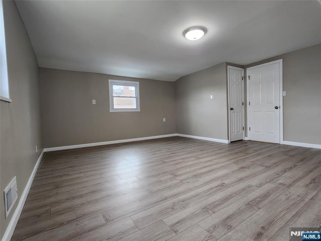 111 Church Street Lodi, NJ 07644 - Photo 12 of 21 an empty room with wooden floor and windows
