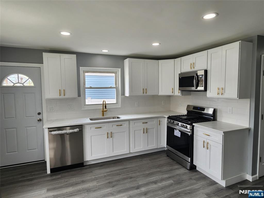 111 Church Street Lodi, NJ 07644 - Photo 8 of 21 a kitchen with stainless steel appliances granite countertop a sink and stove top oven