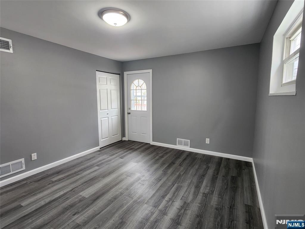 111 Church Street Lodi, NJ 07644 - Photo 9 of 21 an empty room with wooden floor and windows