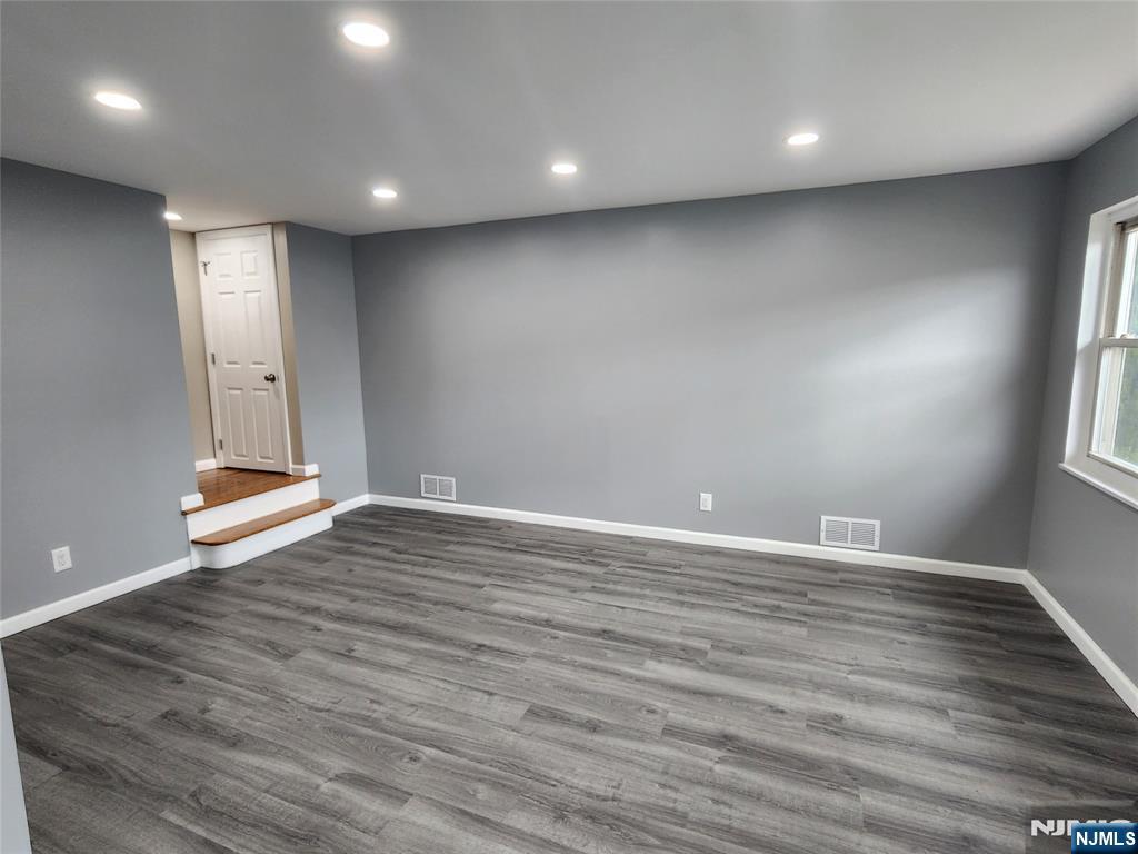 111 Church Street Lodi, NJ 07644 - Photo 10 of 21 an empty room with wooden floor and windows